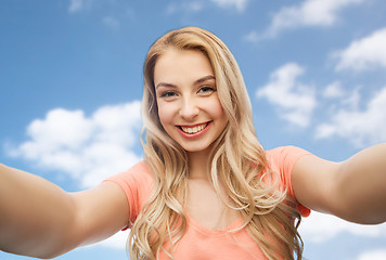 Image showing happy smiling young woman taking selfie