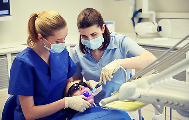 Image showing female dentists treating patient girl teeth