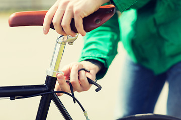 Image showing close up of man adjusting fixed gear bike saddle