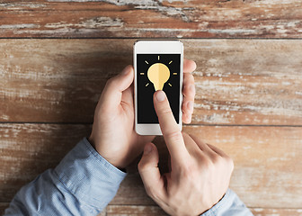 Image showing close up of male hands with smartphone on table