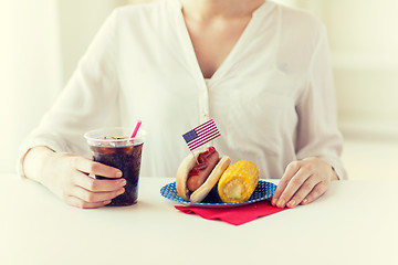 Image showing close up of woman eating hot dog with cola