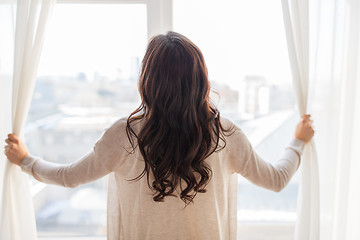 Image showing close up of woman opening window curtains