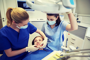 Image showing happy female dentist with patient girl at clinic