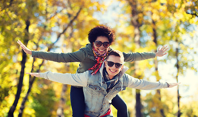 Image showing happy teenage couple in shades having fun outdoors