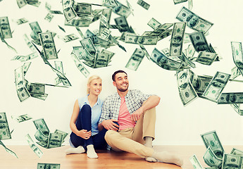 Image showing happy couple at home over dollar money falling