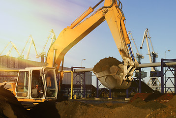 Image showing Hydraulic excavator at work. Shovel bucket and cranes against bl