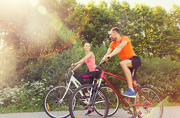 Image showing happy couple riding bicycle outdoors