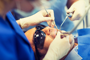 Image showing close up of dentists treating teeth at clinic