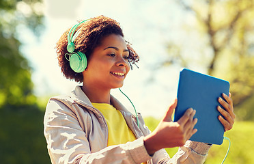 Image showing happy african woman with tablet pc and headphones