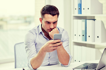 Image showing businessman with smartphone and laptop at office