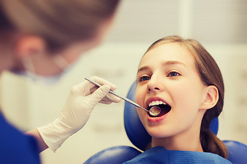 Image showing female dentist checking patient girl teeth