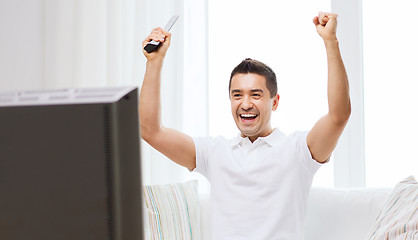 Image showing smiling man watching sports at home