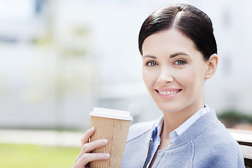 Image showing smiling woman drinking coffee outdoors