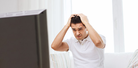 Image showing disappointed man watching tv at home