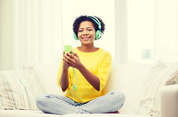 Image showing happy african woman with smartphone and headphones