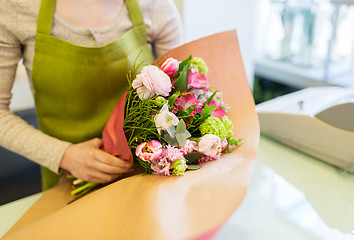 Image showing close up of woman packing bunch at flower shop