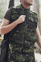 Image showing close up of soldier or hunter with gun in forest