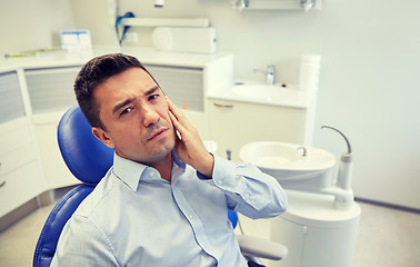 Image showing man having toothache and sitting on dental chair