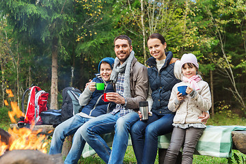 Image showing happy family sitting on bench at camp fire