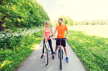 Image showing happy couple riding bicycle outdoors