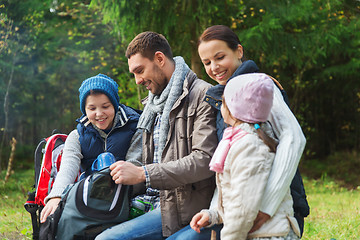 Image showing happy family with backpacks and thermos at camp