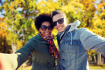 Image showing happy teenage couple taking selfie on city street