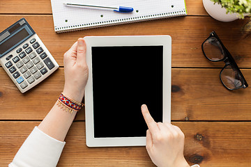 Image showing close up of woman with tablet pc on wooden table