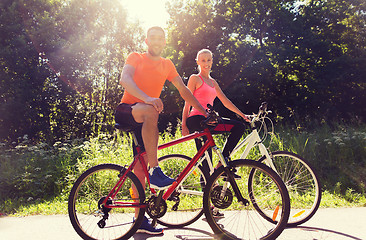 Image showing happy couple riding bicycle outdoors