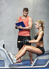 Image showing man and woman flexing muscles on gym machine