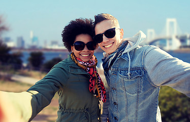 Image showing happy teenage couple taking selfie in tokyo