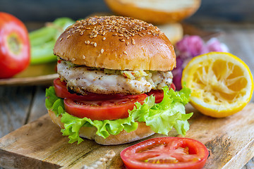 Image showing Burger with vegetables, chicken and spicy sauce.