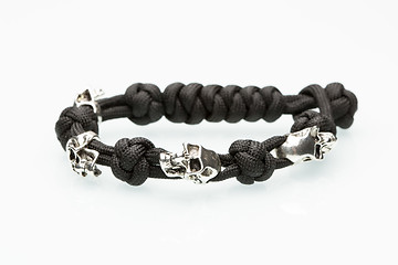 Image showing Black braided bracelet with skulls on white background