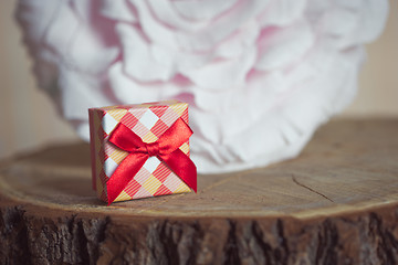 Image showing Gift box with red bow on wood background