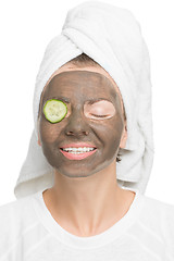 Image showing Young beautiful woman in mask for the face. therapeutic black clay. Spa treatment.