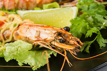 Image showing perfect dish with shrimps on a black plate. seafood