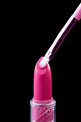 Image showing Tube of lipstick with a brush make-up on black 