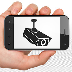 Image showing Privacy concept: Hand Holding Smartphone with Cctv Camera on display