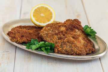 Image showing Schnitzel beef with lemon on a metal tray.