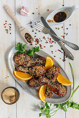 Image showing Fried chicken drumsticks in honey glaze with sesame seeds.