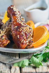 Image showing Fried chicken drumsticks with sesame seeds close-up.