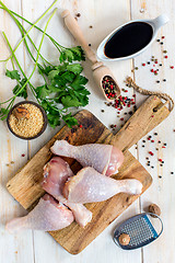 Image showing Raw chicken drumsticks and ingredients for hot sauce.