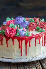 Image showing Cake with flowers and red chocolate icing.