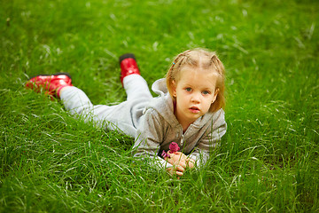 Image showing Portrait of little girl lying on green grass