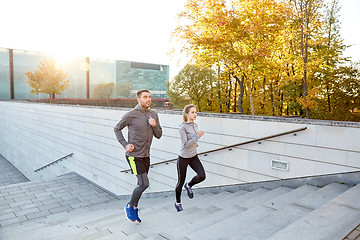 Image showing happy couple running upstairs on city stairs