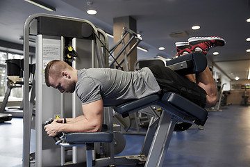 Image showing man flexing leg muscles on gym machine