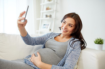 Image showing pregnant woman taking smartphone selfie at home