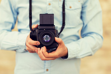 Image showing close up of hipster man with film camera in city