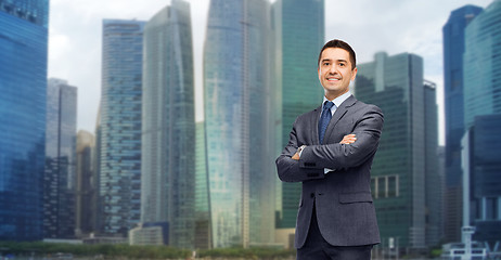 Image showing happy smiling businessman over singapore city 