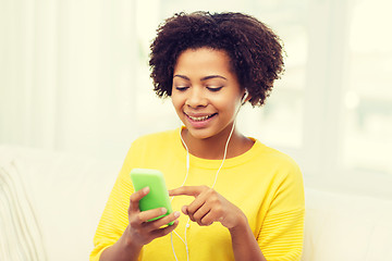 Image showing happy african woman with smartphone and earphones