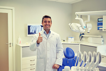 Image showing happy male dentist showing thumbs up at clinic